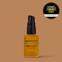 A bottle of Gatherwise Night Serum with a black pump dispenser and amber glass bottle, set against a solid warm brown background. A Beauty Shortlist Awards 2025 badge is displayed in the upper right corner.