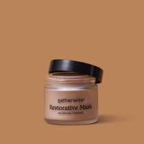 A jar of Gatherwise Restorative Mask and Blemish Treatment with a black lid, set against a solid warm tan background.